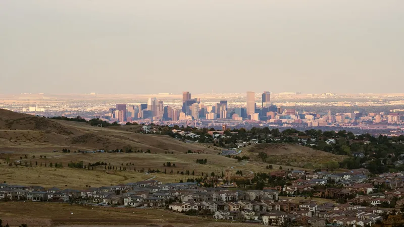 Evening light over the metro skyline seen from Aurora's open plains side, mountains far on the horizon