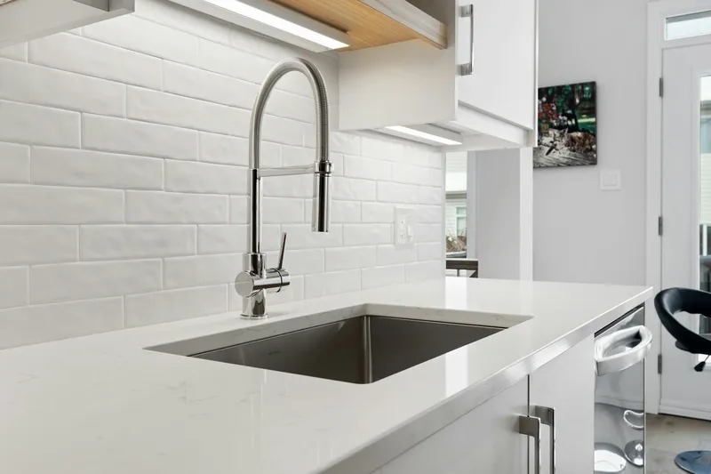 A clean modern kitchen faucet running in a remodeled cottage kitchen a few blocks off Public Road in Lafayette, Colorado