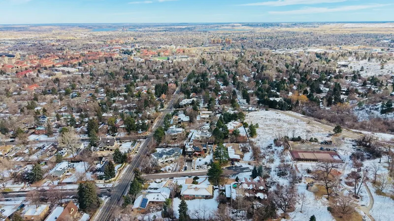 Snow settling over a Northglenn street of matching 1960s ranch homes on the north metro rise