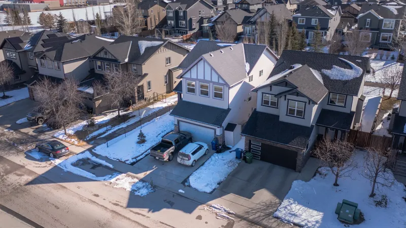 Snow across a Firestone subdivision of newer two-story homes with bare young trees along the street